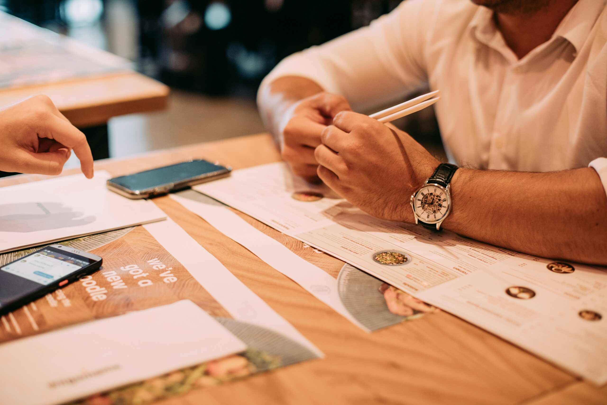Two people having a casual coffee meeting indoors at a modern cafe table.